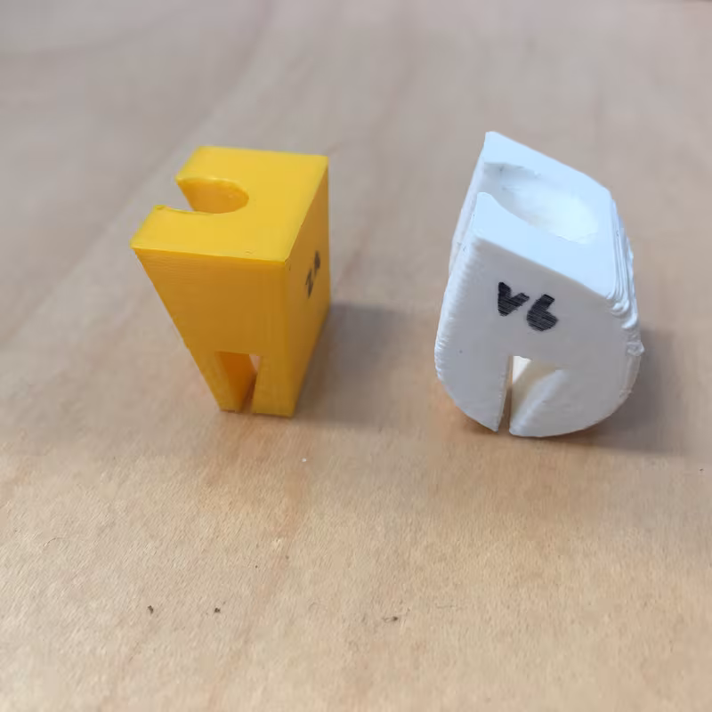 Two revisions side by side on a wooden desk: an angular yellow version and a rounded white one marked v4